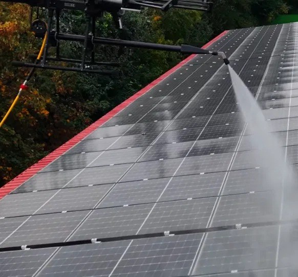 Dron limpiando placas solares con agua a presión